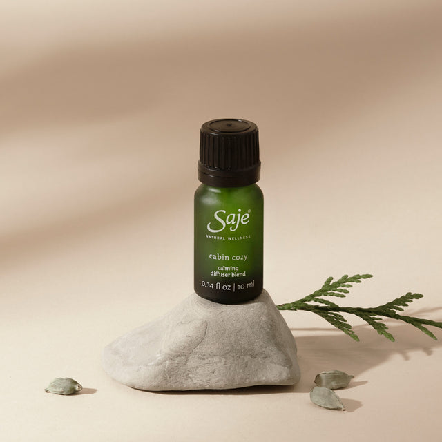 Cabin cozy calming diffuser blend on a rock with a beige background
