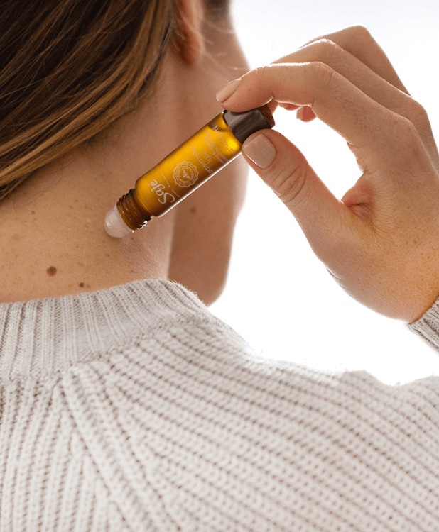 A person rolls a remedy roll-on on their palm.