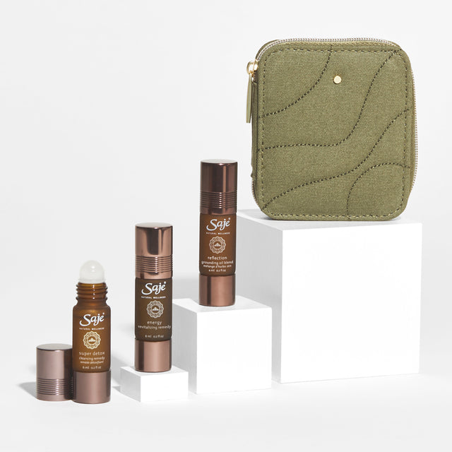 Mind & Body Reset product image with army green case and three roll-ons: super detox, energy and reflection on white pedestals starting from low on the left to high on the right