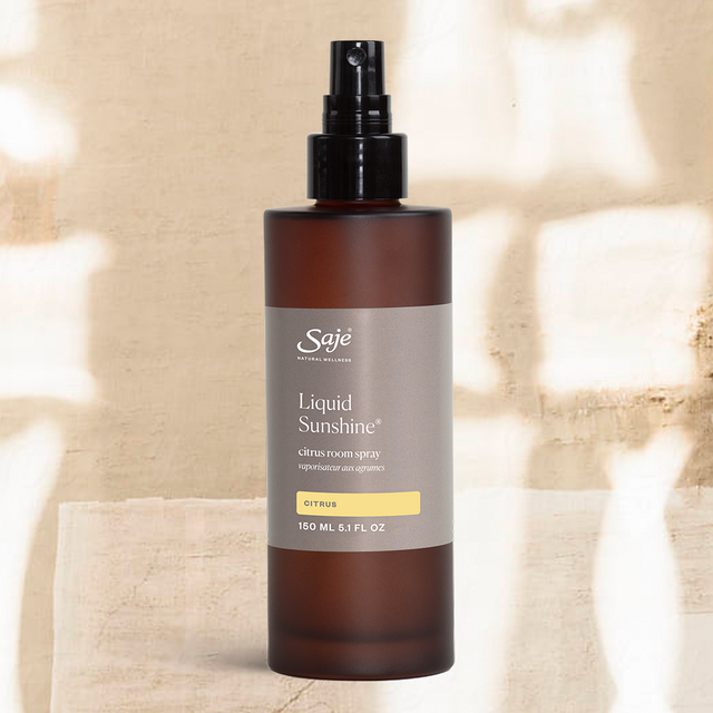 Liquid Sunshine room spray on a clay wall background with shadows