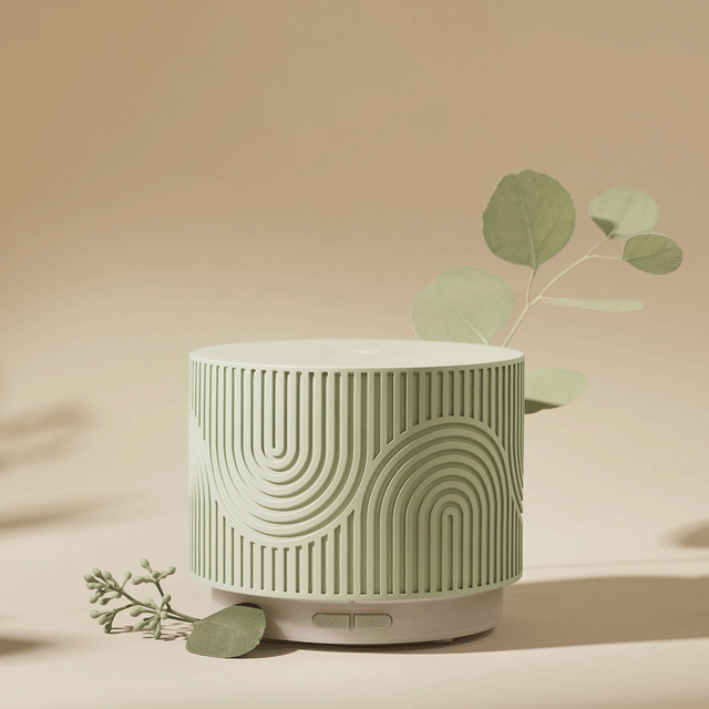 Aroma Nook Pistachio gif with eucalyptus leaves around it on a beige background