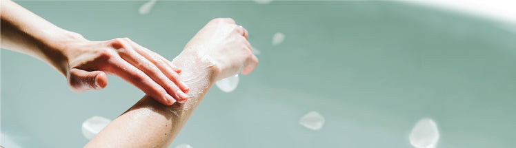A person applying moisturizer to their forearm