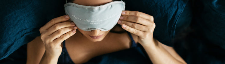 A woman putting on their eye mask 