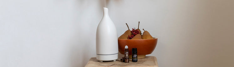 Aroma Om diffuser placed with a bowl of pears and diffuser blends