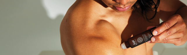 A man applies Extra Strength Roll-On to a muscle on his upper arm.