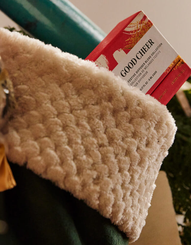 Saje packaging in a beige stocking, green wrapping paper in the background.