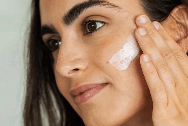 woman applying moisturizer on her face