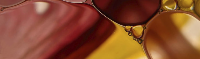 A close up of oil droplets on a yellow and red background