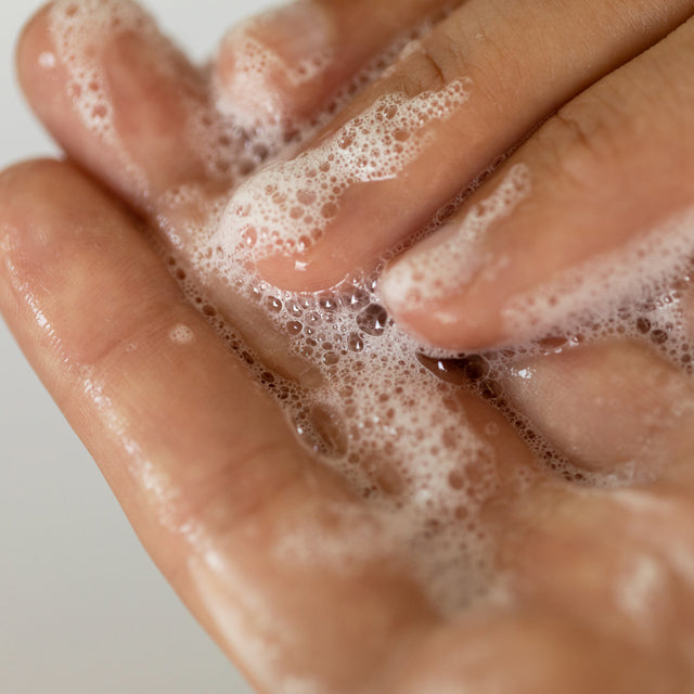 A person rubbing the Calm-O-Mile gel cleanser in-between their hands 