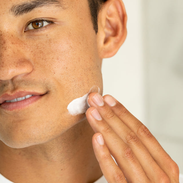 person applying Claritea moisturizer on face