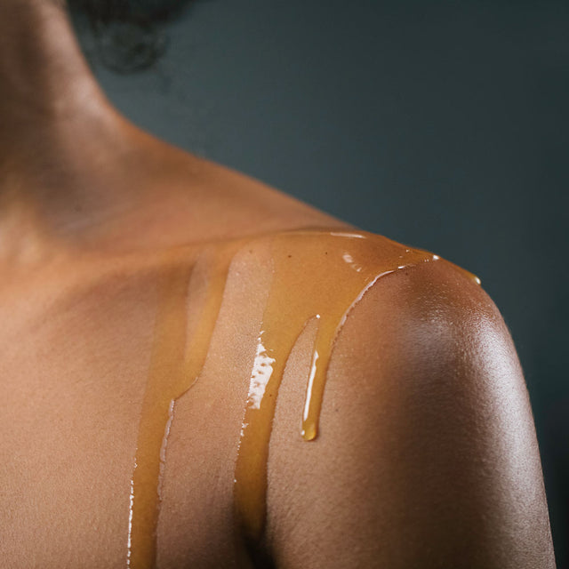 Stress release body oil dripping down a person shoulder 