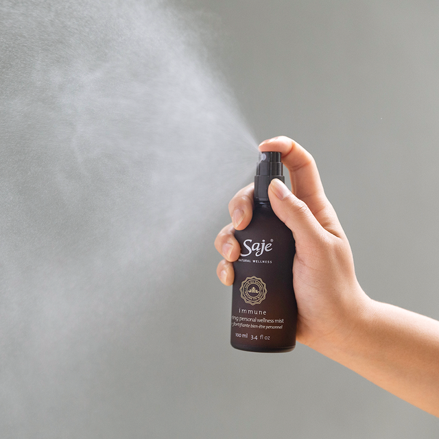A person spraying the Immune personal wellness mist into the air 