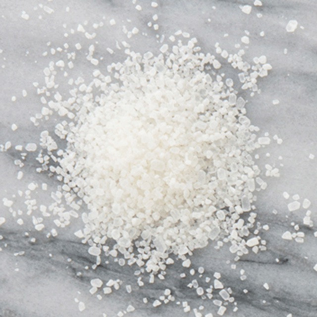 Bath salts in a pile on counter top, showing the salt texture