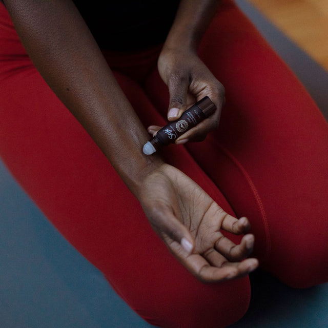 person applying Yoga 10 ml roll-on to wrist